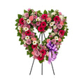 Cœur funéraire sur trépied, en roses lavande, gerberas fuchsia et marguerites, avec un ruban mauve
