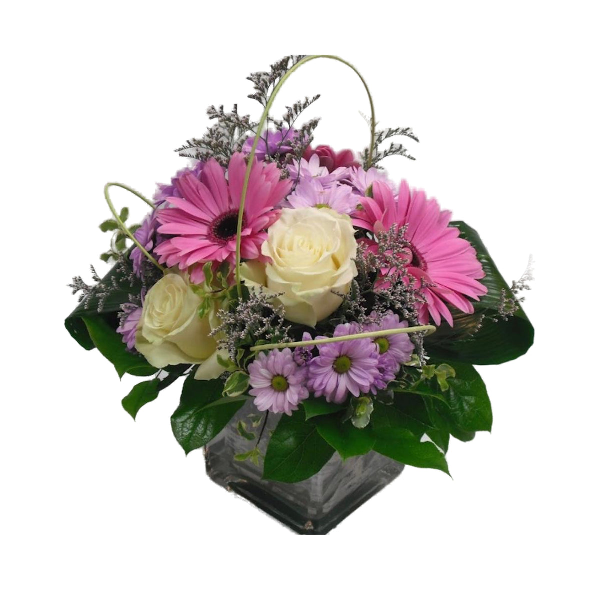 Arrangement en gerberas roses, roses blanches et marguerites, dans un vase de verre